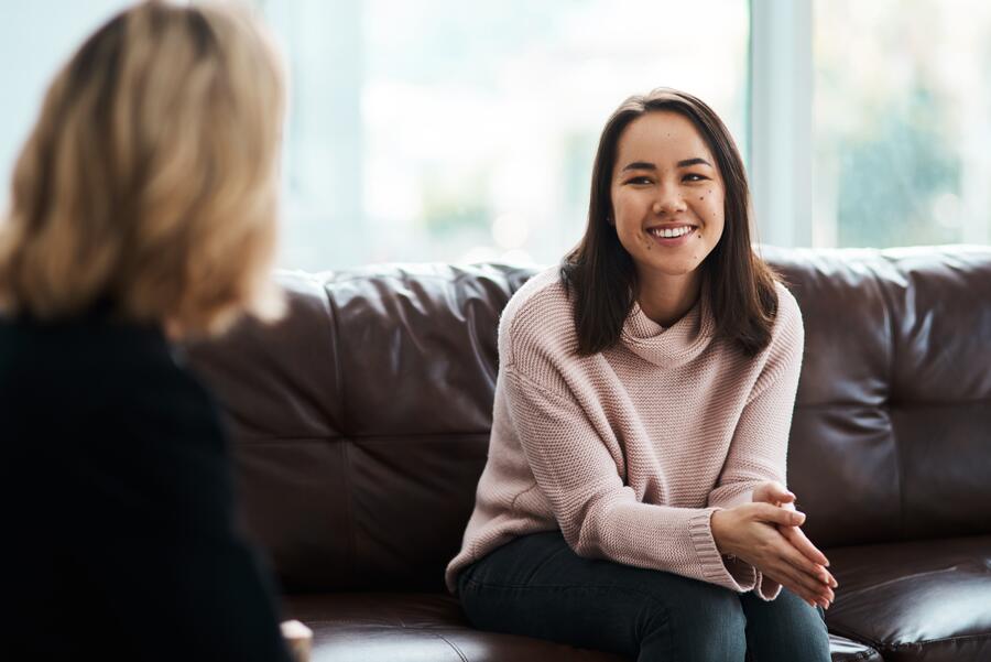 A therapist and client in a calm, sunlit office, focused and engaged in conversation.